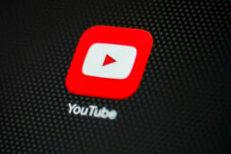 Close ups image of the YouTube app logo on an iPhone.